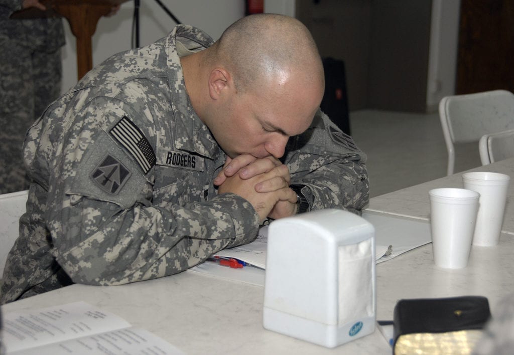 U.S. Army Capt. Adin Rodgers, a chaplain, bows his head in prayer at the dining facility, Forward Operating Base Marez, Mosul, Iraq, July 11, 2008, during a prayer breakfast. Rodgers is assigned to 1st Battalion, 163rd Field Artillery Regiment. (U.S. Army photo by Pfc. Sarah De Boise/Released)