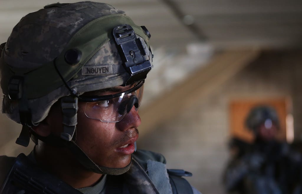 FORT IRWIN, Calif. -U.S. Army Spc. Kevin Nguyen from Charlie Company, 4th Battalion, 23rd Infantry Regiment, 2nd Stryker Brigade Combat Team, 2nd Infantry Division, go door-to-door clearing buildings looking for a high value target at the National Training Center here, June 20, 2014. Decisive action rotations are geared toward an adaptive enemy in a complex environment. (U.S. Army photo by Spc. Charles Probst, Operations Group, National Training Center)