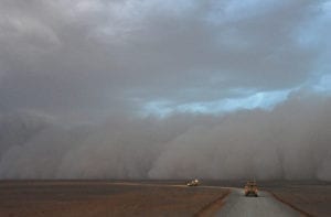 A dust storm approaches a convoy.