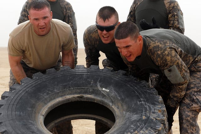 A team of five soldiers, assigned to the 1st Brigade Combat Team, 1st Cavalry Division, flip a tire during the Tough Mudder Centurion Challenge, April 21. The tire-flip is one of 13 obstacles that teams must complete before moving on to the next obstacle in the four and a half mile course while running against the clock.