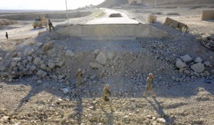 Military engineers from Provincial Reconstruction Team Zabul and the 2nd Stryker Calvary Regiment walk through the rubble of a bridge construction site on Highway 1 during a quality assurance, quality control visit on Nov. 14, 2010. PRT Zabul is comprised of Air Force, Army, Department of State, U.S. Agency for International Development and U.S. Department of Agriculture personnel who work with the government of Afghanistan to improve governance, stability, and development throughout the province. (U.S. Air Force photo by Staff Sgt. Brian Ferguson)