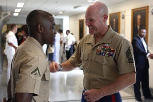 Sgt. Maj. of the Marine Corps Micheal P. Barret motivates Lance Cpl. Ethan Cadore during the unveiling of the Navy's tribute to African American leadership Mural. Cadore was one of six sentries standing guard for the ceremony. The mural honors African Americans who led the way in both the Navy and the Marine Corps.