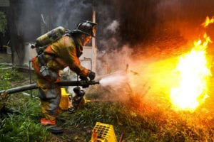 Army Pvt. 1st Class Lucas Ternell, a volunteer firefighter, and a member of the 20th Military Police Company, Maryland National Guard, puts out a small debis fire in the yard of a house fire in Salisbury, Md., Aug. 27, 2011. Ternell was aboard Rescue 16, which was one of several fire and rescue engines that reported to the fire inside a residential neighborhood. Guard members and civilian first responders are providing area support during the Hurricane Irene response. (U.S. Army photo by Sgt. Darron Salzer)(Released)