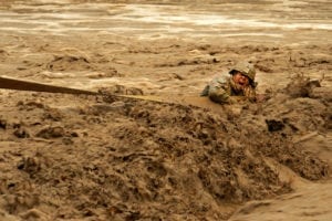 U.S. Army Staff Sgt. Patrick Reynolds, Security Forces squad leader attached to Provincial Reconstruction Team Zabul, fights racing water while holding onto a tow strap attached to an Afghan National Army vehicle stuck in the Lurah River in Shinkai district, Afghanistan, Oct. 12. The ANA asked PRT Zabul for assistance because of the PRT's vehicle recovery capabilities. PRT Zabul and ANA conduct frequent joint operations and have had great progress working together in the Shinkai district. Reynolds is deployed from Charlie Company, 182nd Infantry Division, Massachusetts National Guard.