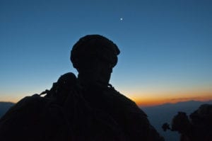 KUNAR PROVINCE, Afghanistan (November 29, 2010) – A Soldier from Bushmaster Company, 1st Battalion, 327th Infantry Regiment, Task Force Bulldog takes a short breather on a mountainside at about 7,000 feet as the sun rises over the Pech River Valley in eastern Afghanistan’s Kunar Province, Nov. 23. The Soldiers teamed up with members of the Afghan National Army during a month long series of operations to clear some of the most dangerous parts of Task Force Bulldog’s area of operations. (Photo by U.S. Army Staff Sgt. Mark Burrell, 210th Mobile Public Affairs Detachment)