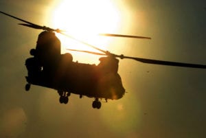 A CH-47 passes in front of the sun after dropping off a part for an improved river bridge on the Arkansas River during River Assault 11 at Fort Chaffee, Ark.