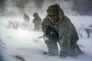 Staff Sgt. Benjamin Reynolds, 891st Missile Security Forces Squadron response force leader, crouches in rotor wash during a field training exercise at Turtle Mountain State Forest, N.D., Feb. 14, 2018. During the exercise, 91st Security Forces Group defenders coordinated simulated medical evacuations with two 54th Helicopter Squadron UH-1N Iroquois. (U.S. Air Force photo by Senior Airman J.T. Armstrong)