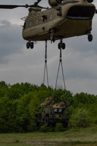 An Army Ground Mobility Vehicle (AGMV) is lowered to the ground by a CH-47 Chinook helicopter during exercise Immediate Response 19 at Military Training Area Eugen Kvaternik, Croatia, May 18, 2019. This is the first operational use of the new vehicle, designed to be more agile and mobile than other types of vehicles commonly used by the U.S. Military. (U.S. Army photo by Pvt. Laurie Ellen Schubert, 5th Mobile Public Affairs Detachment)