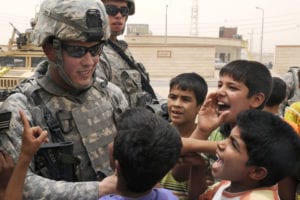 U.S. Army Staff Sgt. Victor Kizer, from Imperial, Mo., assigned to Bravo Company, 445th Civil Affairs Battalion, passes out toys to local Iraqi children, during the project assessments of the Basra Talent School, Al Jameat and Al Quibla Markets, to evaluate the measures of performance and effectiveness of the Commander Emergency Response Program projects, in Basra, Iraq, July 29, 2009.