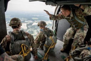 A Jump Master assigned to 3rd Special Forces Group (Airborne) gives the command of GO to a paratrooper during an airborne operation in honor of the 101st birthday of the Warrant Officer Corps July 19, 2019 at Fort Bragg, N.C. To honor the 101st birthday of the Warrant Officer Corps, 3rd SFG (A) had a luncheon that proceeded a cake cutting conducted by the oldest and the youngest Warrant Officer who attended the event and conducted an airborne operation. (U.S. Army photo by Sgt. Steven Lewis)