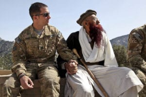 KUNAR PROVINCE, Afghanistan  U.S. Army Capt. Mark Moretti, commander of Company B, 2nd Battalion, 12th Infantry Regiment, Task Force Lethal Warrior, sits hand-in-hand with Shamshir Khan, one of the most senior Korengal Valley elders, April 13, at the Korengal Outpost in Kunar province, Afghanistan. Moretti, who has led the Soldiers of Baker Company at the KOP since 2009, welcomed Khan and the rest of the Korengali elders onto the KOP to provide them an orientation of all the buildings and equipment that would be left behind for the people of the valley to utilize. International Security Assistance Forces and Afghan National Security Forces completed the repositioning of forces out of the Korengal Valley into more populated areas in accordance with the ISAF counterinsurgency strategy early April 14, 2010. (Photo by U.S. Army Spc. David Jackson, 55th Signal Company)