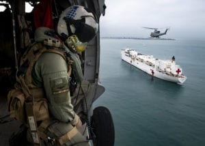 CALLAO, Peru (July 14, 2019) Naval Aircrewman (Helicopter) 1st Class Robert P. McCann, from New Freedom, Pa., flies in an MH-60S Sea Hawk helicopter alongside a Peruvian military Bell 412 over the hospital ship USNS Comfort (T-AH 20). Comfort is working with health and government partners in Central America, South America, and the Caribbean to provide care on the ship and at land-based medical sites, helping to relieve pressure on national medical systems strained by an increase in Venezuelan migrants. (U.S. Navy photo by Mass Communication Specialist 2nd Class Morgan K. Nall/Released)190714-N-IA905-1073